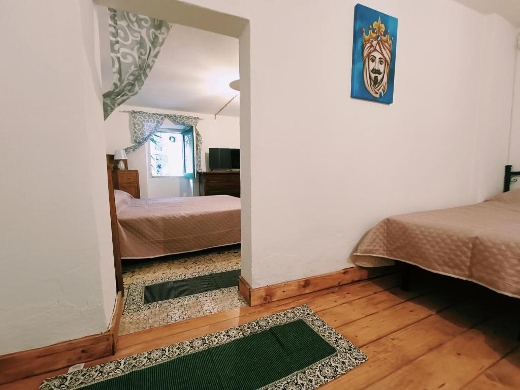 a room with two beds and a hallway with a bedroom at Albergo Diffuso Borgo Santa Caterina "Quartire Hebraic" in Castiglione di Sicilia