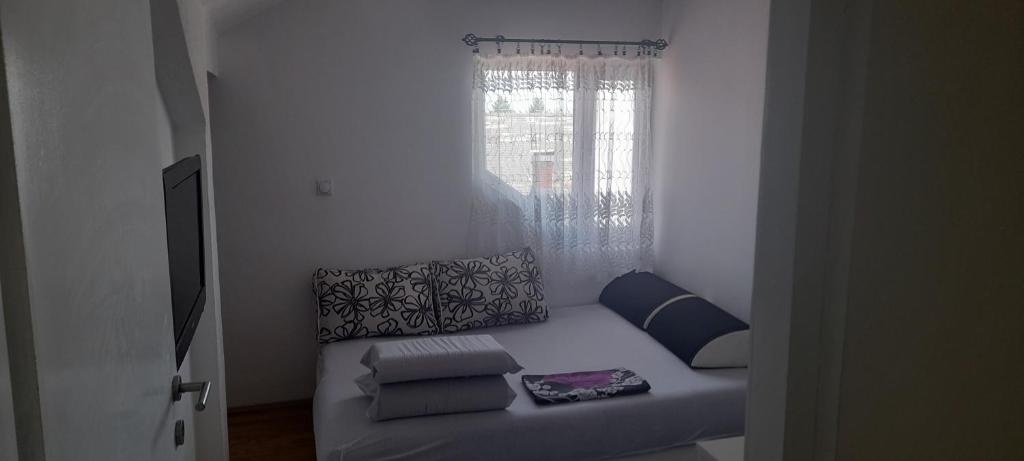 a couch sitting in a room with a window at Stan na dan -Bratunac- in Bratunac