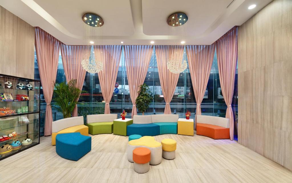 Elle comprend un salon doté d'un mobilier coloré et de grandes fenêtres. dans l'établissement Holiday Inn Express Chengdu Wuhou, an IHG Hotel, à Chengdu