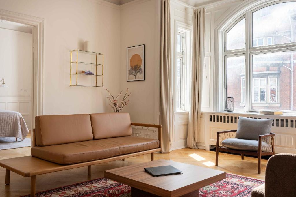 a living room with a couch and a chair at Lovely 3BR Manor Flat 5 min from Tivoli Gardens in Copenhagen