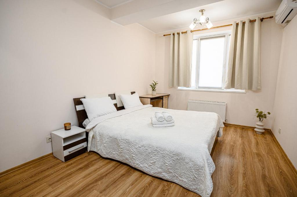 a white bedroom with a bed and a window at Retreat relaxant cu 2 dormitoare! in Chişinău