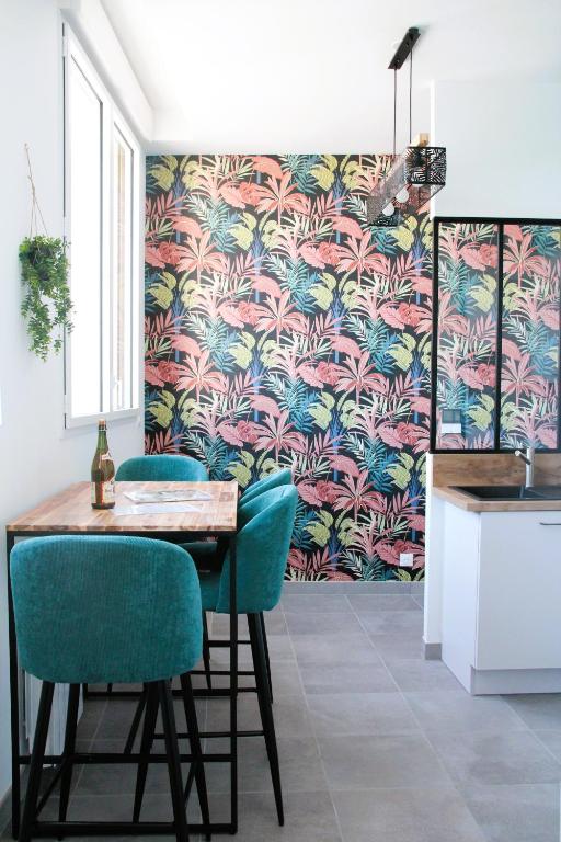 une cuisine avec une table et des chaises avec un papier peint dans l'établissement Le Freesia, à 20m de la plage, 5 min du centre-ville, à Roscoff