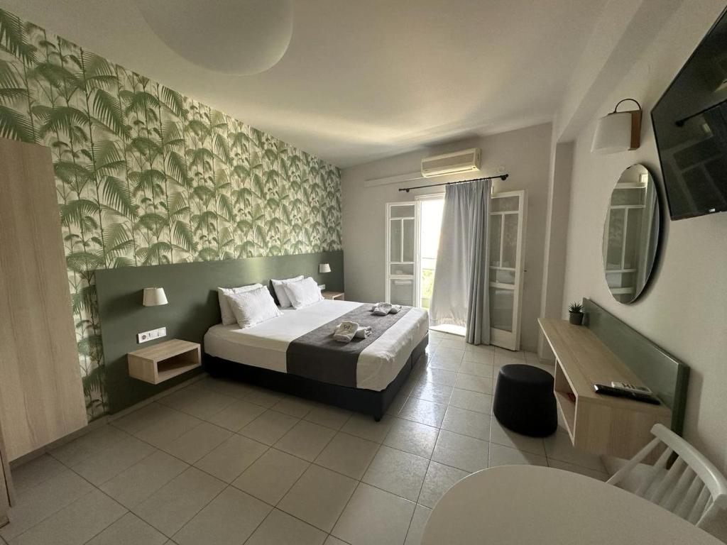 pokój hotelowy z łóżkiem i oknem w obiekcie Sunshine Studios w mieście Malia