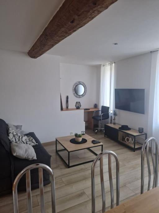 - un salon avec un canapé, une télévision et des chaises dans l'établissement Appartement dans le Faubourg proche de la plage, à Collioure