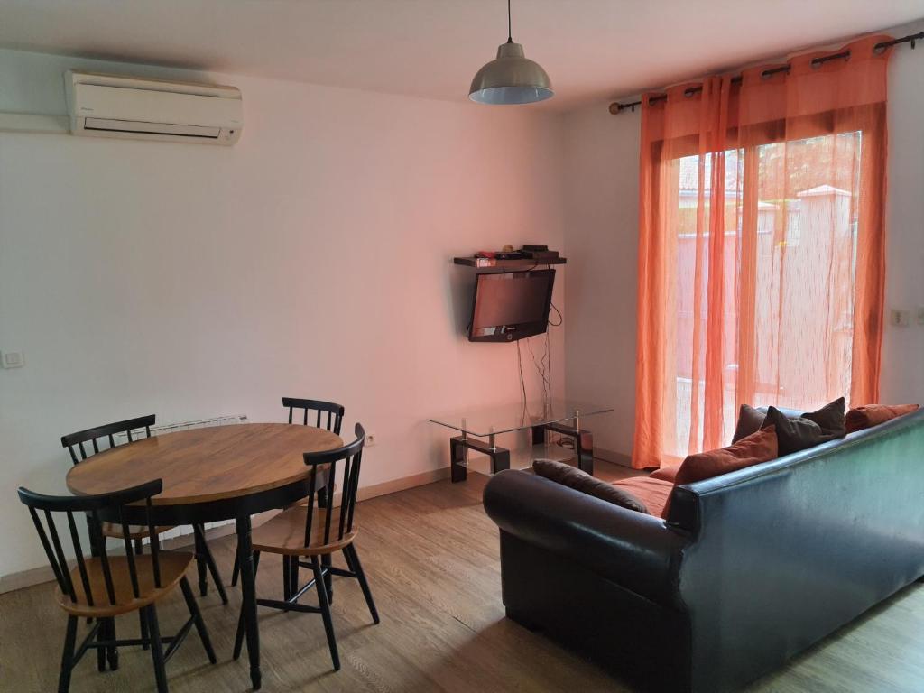 un salon avec une table et un canapé dans l'établissement Gite le voisin Toulousain 1, à Toulouse