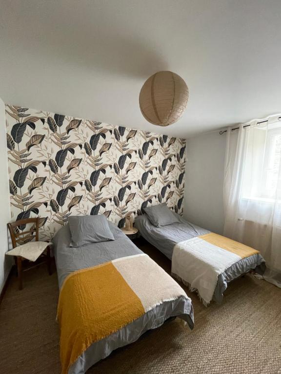 a bedroom with two beds and a wall at Maison côté halle " Le Parc" in Saint-Flour