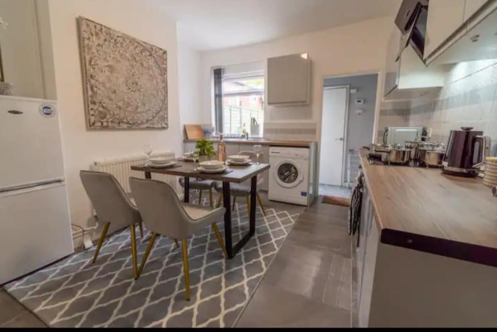 a kitchen with a table and chairs in a room at Beautiful Home near City Centre in Nottingham