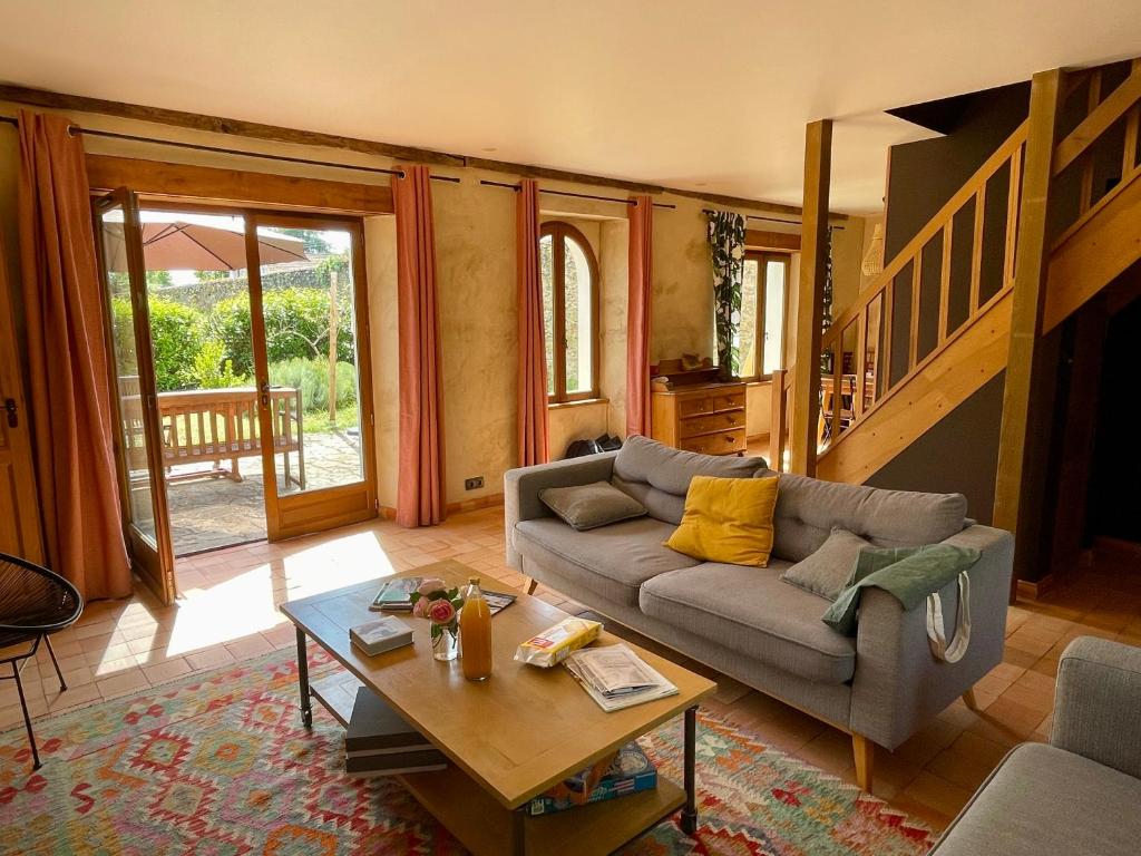 a living room with a couch and a coffee table at Maison avec jardin - L'Orangerie in Thouaré-sur-Loire