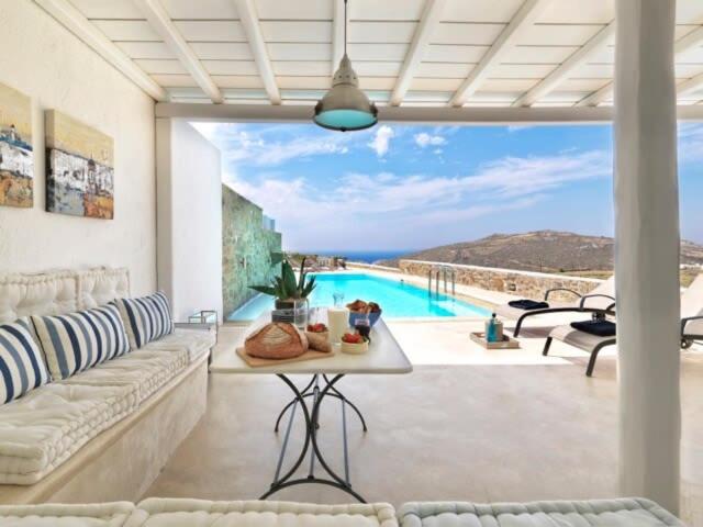 un salon avec un canapé et une piscine dans l'établissement Villa Mare, Mykonos, à Kalafatis
