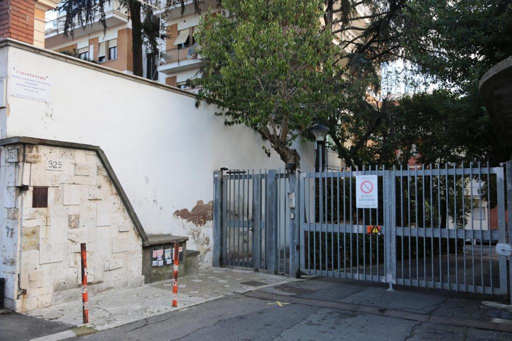 una puerta azul frente a un edificio con un árbol en Casa Piccole Ancelle di Cristo Re en Roma