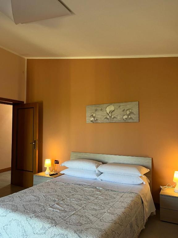 a bedroom with a large bed with two lamps at ROOM365 in Lanciano
