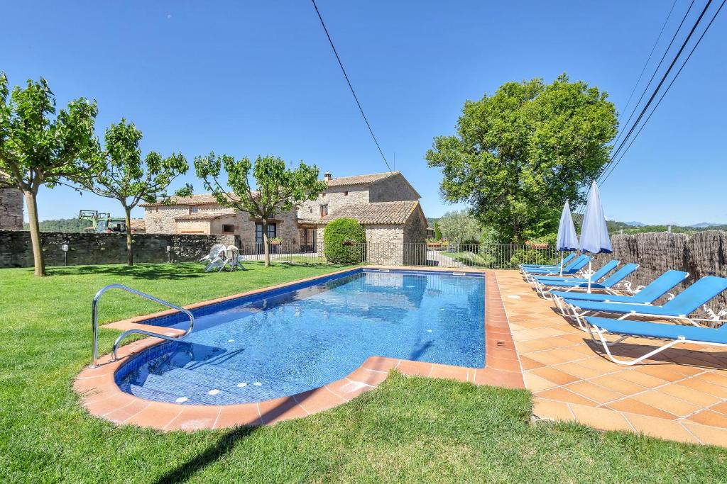una piscina en un patio con tumbonas en Cal Masover, en Sant Boi de Lluçanès