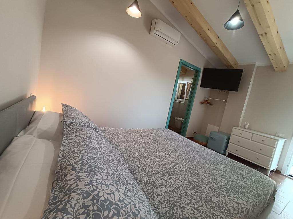 1 dormitorio con 1 cama, vestidor y TV en Agriturismo Al posto giusto, en Piombino