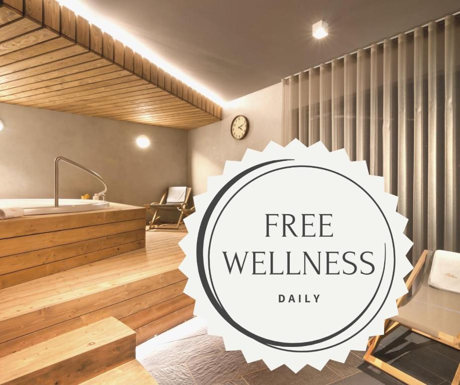 ein Bad mit einer Badewanne und ein Schild mit der Aufschrift „free wellnessedia“ in der Unterkunft Wellness Hotel Grand in Špindlerův Mlýn