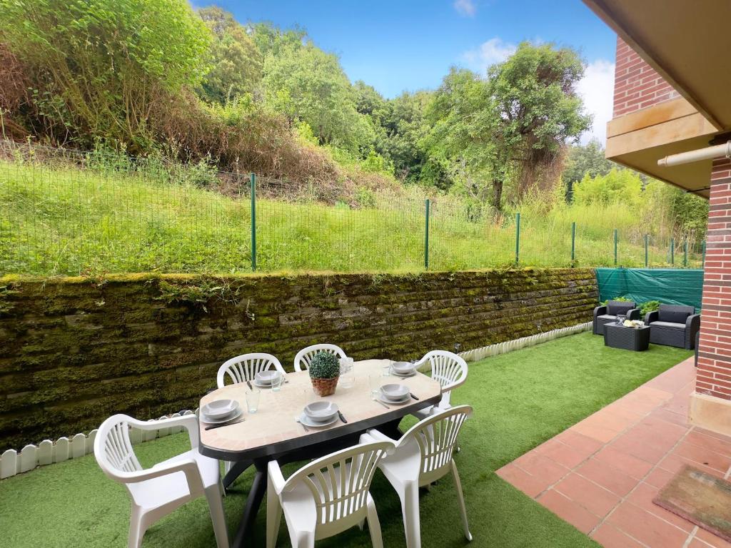 a table and chairs on a patio with a garden at Villa Mercedes - 17001 in Santoña