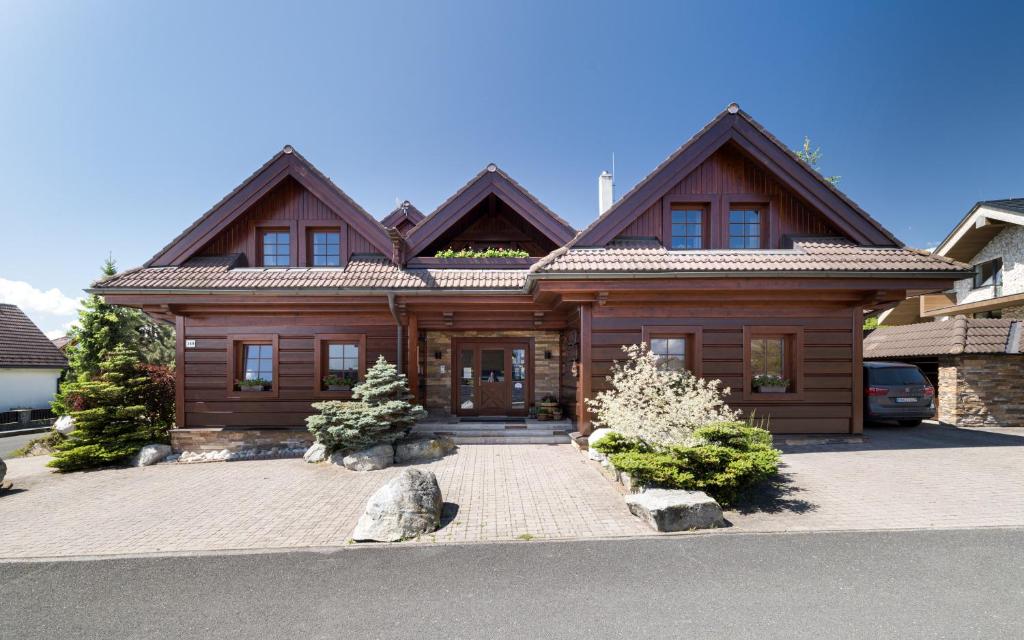 a wooden house with a car parked in front of it at Vila GRAND in Smokovce