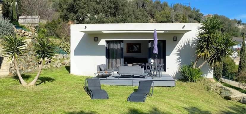 Una pequeña casa con un patio con sillas en un patio. en Havre de paix, en Bastia