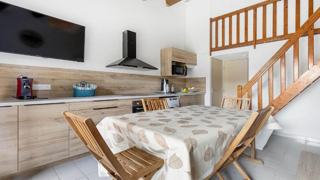 d'une salle à manger avec une table, des chaises et une télévision. dans l'établissement Les Ondines 2- 29- Maison charme- 6 pers, au Cap d'Agde