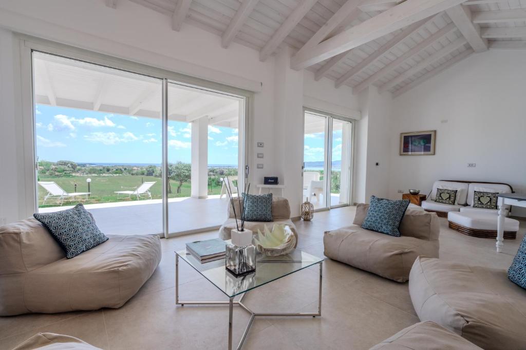 a living room with a couch and a glass table at Villa DEG Vista Mare San Teodoro Puntaldia in San Teodoro