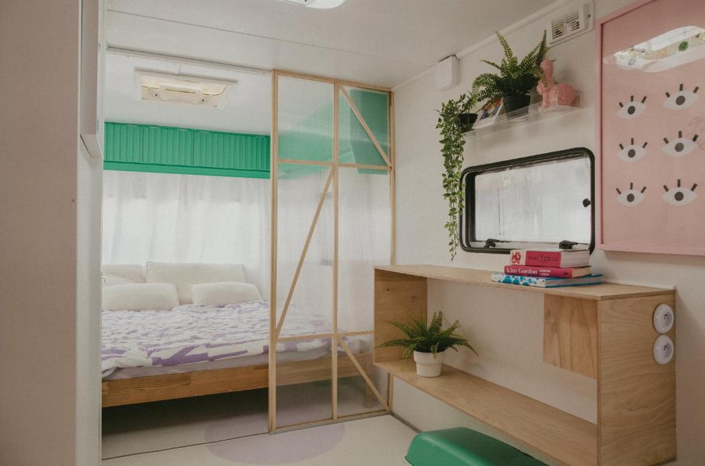 a small bedroom with a bed and a mirror at Bueno Campers - lux przyczepy na wynajem in Jastarnia