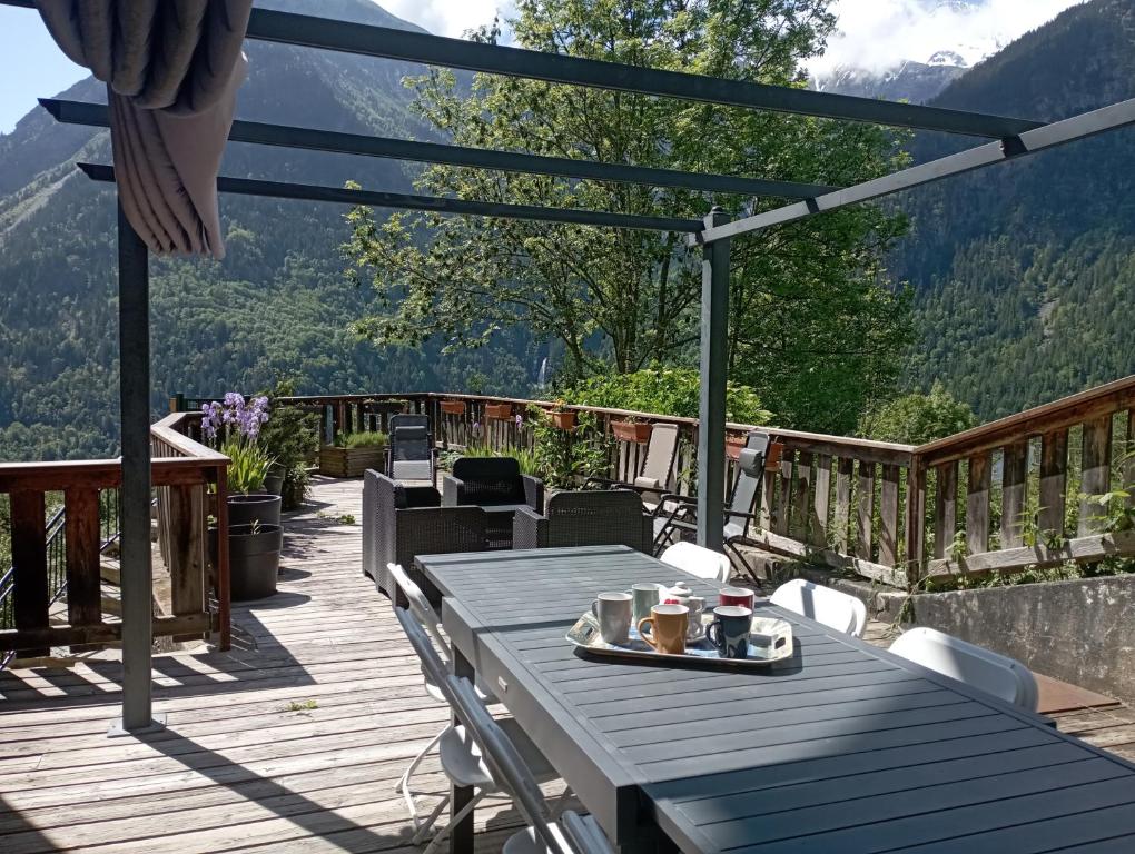 einen Picknicktisch auf einer Terrasse mit Bergblick in der Unterkunft Chalet les Alpes - Le Sapey in Vénosc