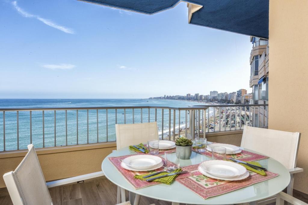 a table with chairs and a view of the ocean at Apartamento de lujo con vistas in Fuengirola