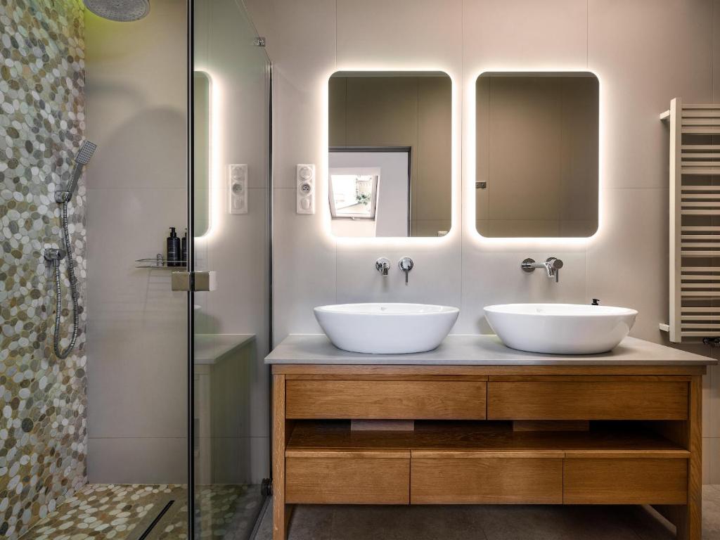 dwie umywalki w łazience z dwoma lustrami w obiekcie Tyzenhauz Villas w Krakowie