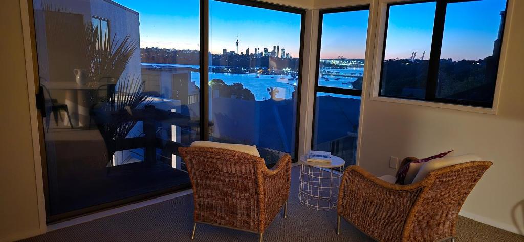 a room with two chairs and a window with a view at 2 Bedroom home, City and Sea Views in Auckland