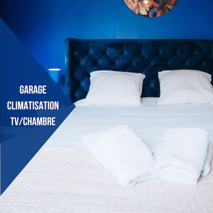 - un lit bleu avec des draps et des oreillers blancs dans l'établissement La Maison Bonheur - Parking Privé - Netflix - Fibre, à Châteauroux
