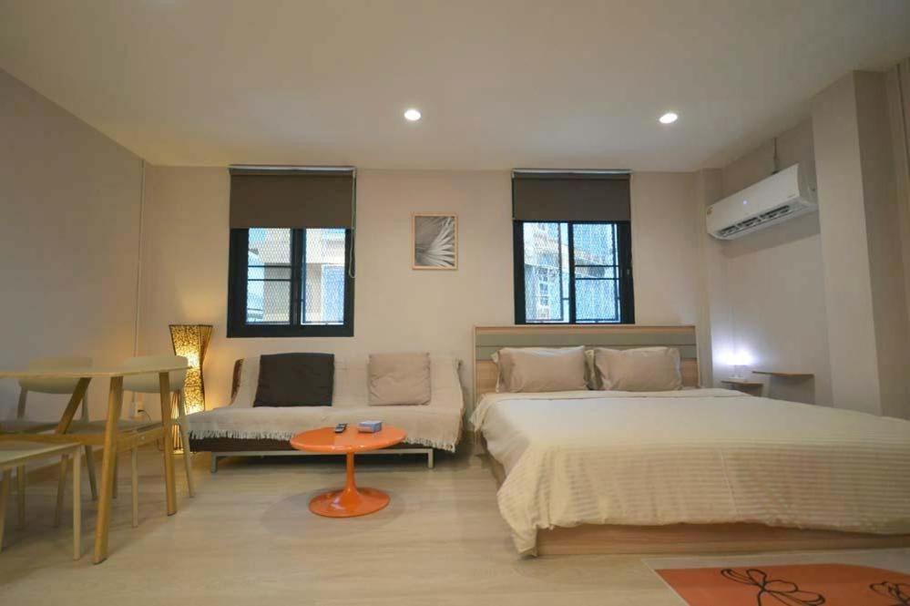 a bedroom with a bed and a table in it at 57 Hidden House BKK Chinatown in Bangkok