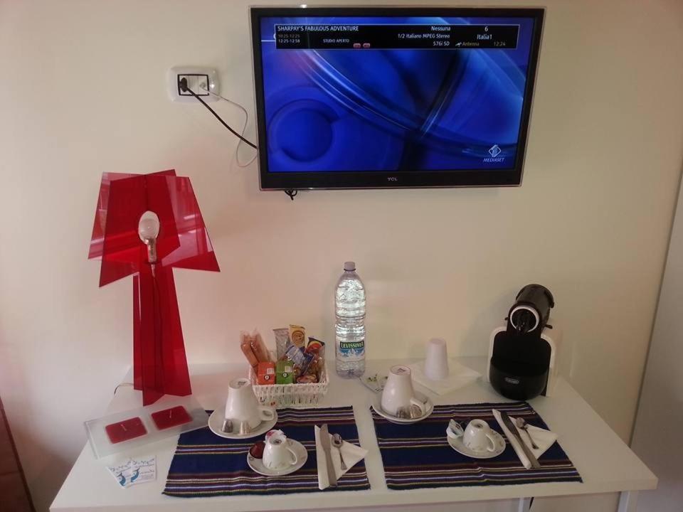 a table with a cross and a tv on a wall at Clorinda's rooms in Bari