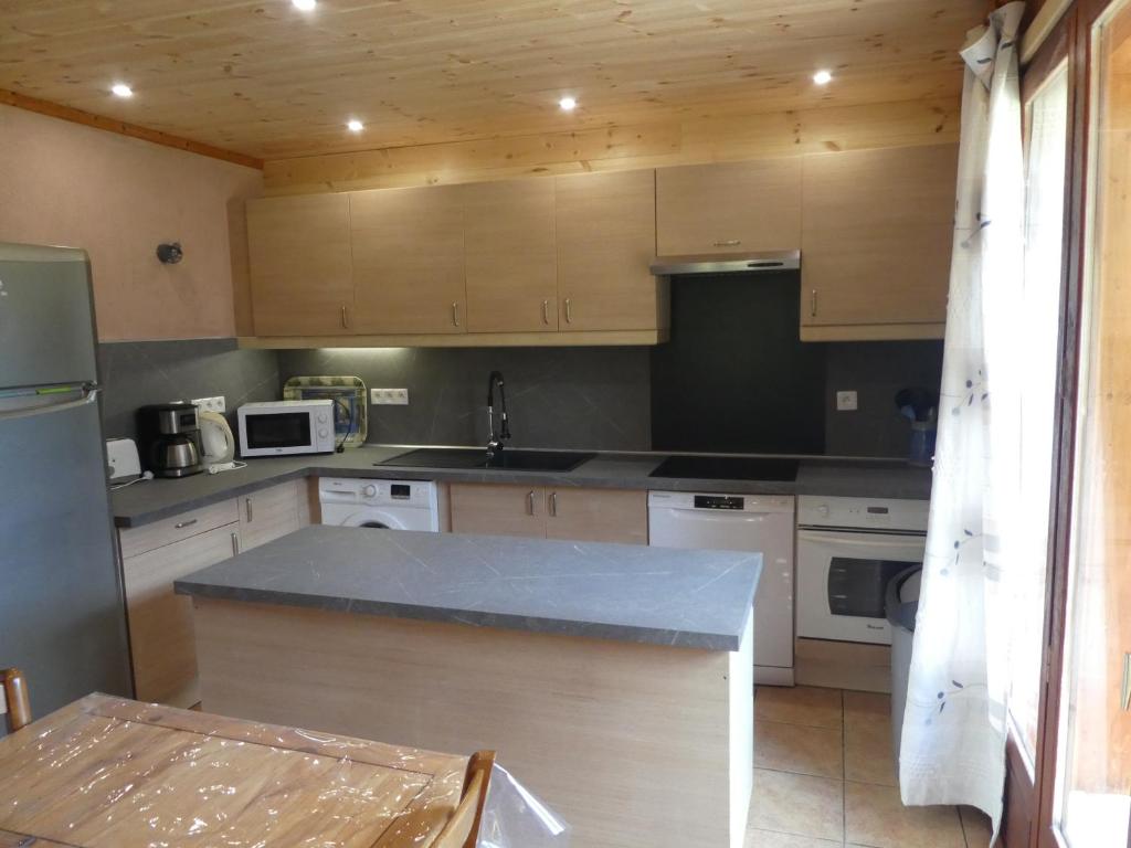 eine Küche mit Holzschränken und einer Arbeitsplatte in der Unterkunft Chalet les Alpes - Le Sapey in Vénosc