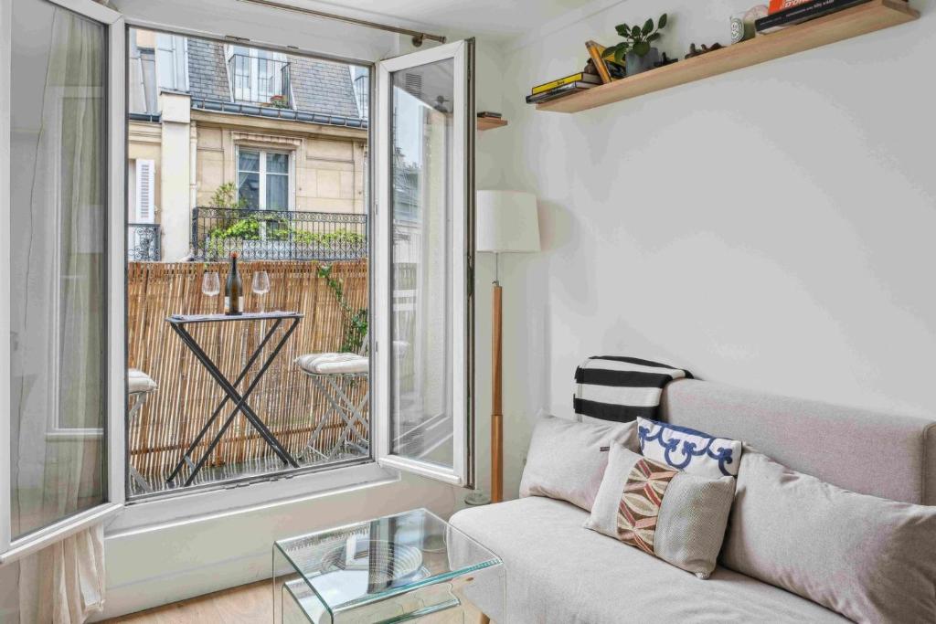 un salon avec un canapé et une table en verre dans l'établissement Le Trésor, à Paris