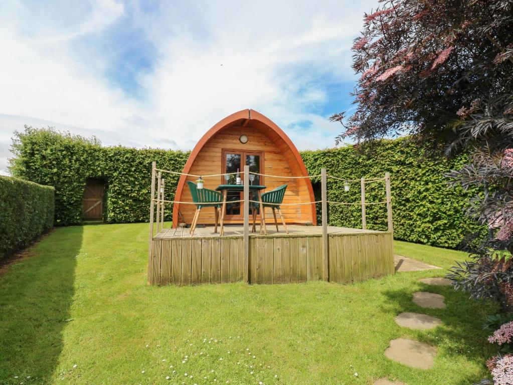 a tiny house with a table and chairs in a yard at Lovesome Pod in Northallerton