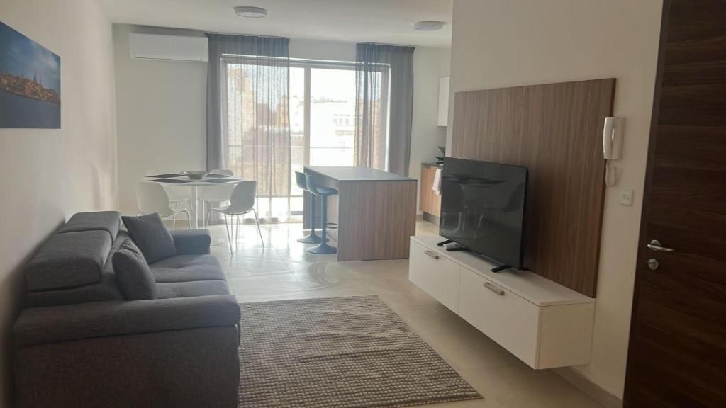 ムサイダにあるUBM Msidaのソファと薄型テレビのあるリビングルーム