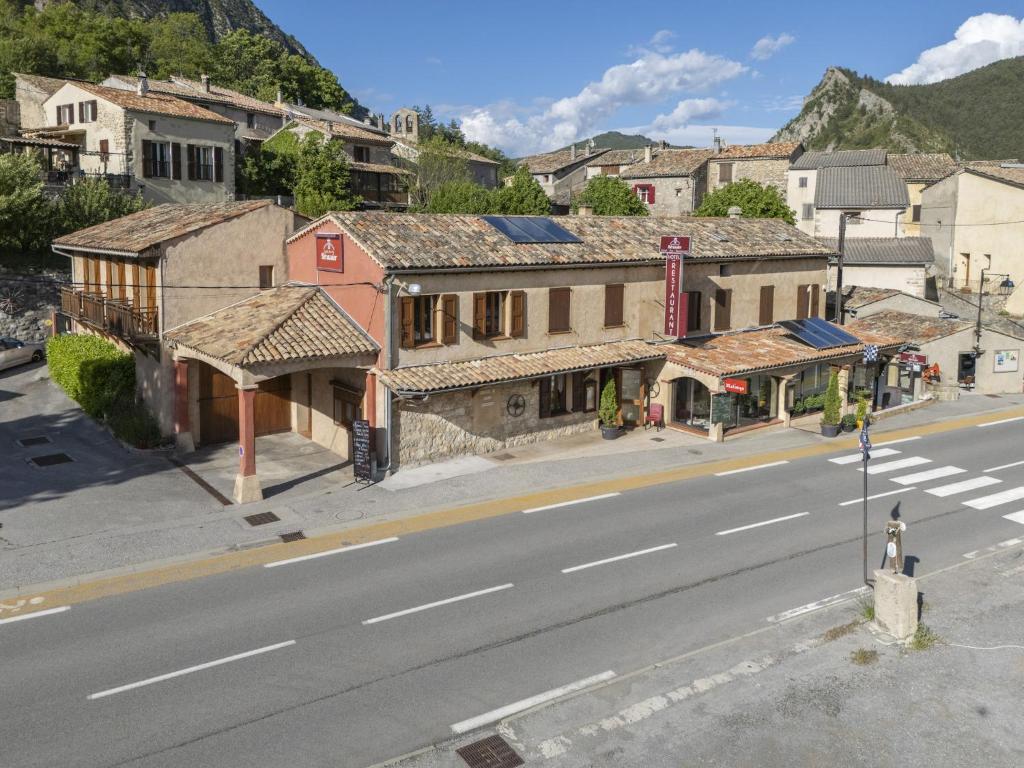 an empty street in a small town with buildings at Le relais du becassier in Annot