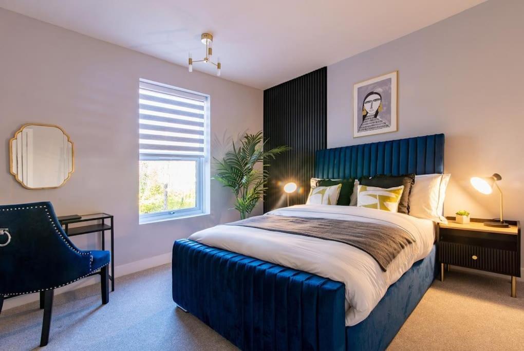 a bedroom with a large bed with a blue headboard at Glasswing Stays Margaret st, central Sheffield in Sheffield