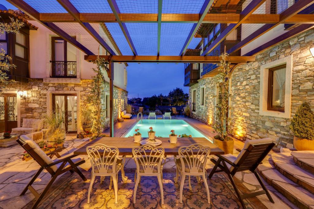 a patio with a table and chairs and a pool at Akanthus Hotel Ephesus in Selcuk