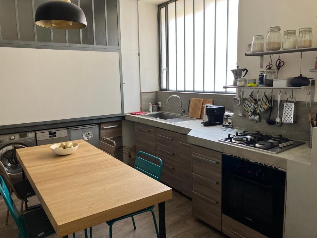 - une cuisine avec une table, un évier, une table et une cuisinière dans l'établissement Loft dans le centre-ville de Hyères, à Hyères