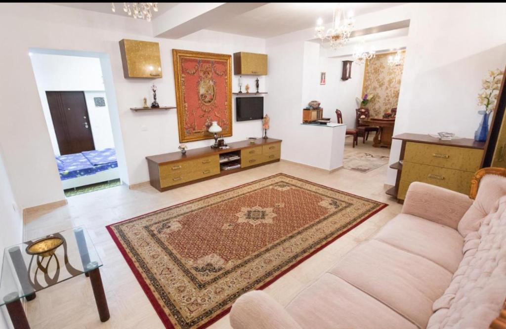 una sala de estar con un sofá y una alfombra en NEW Burgeois Berindey Apartment - Universitate, en Bucarest