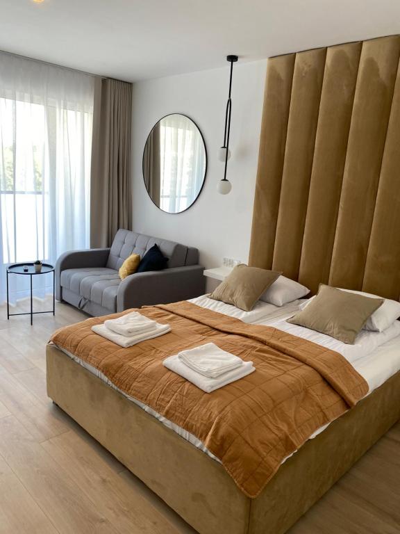 Un dormitorio con una cama grande con un cabecero grande. en TOMALE-AMT Apartamenty Kasprowicza Kołobrzeg - basen, jacuzzi, sauna, siłownia w cenie apartamentu, en Kołobrzeg