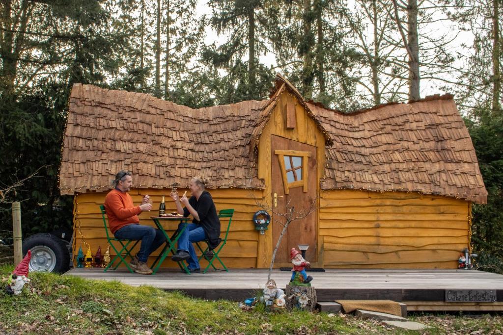 two people sitting at a table in a play house at les Refuges du Chalet in Sart-lez-Spa