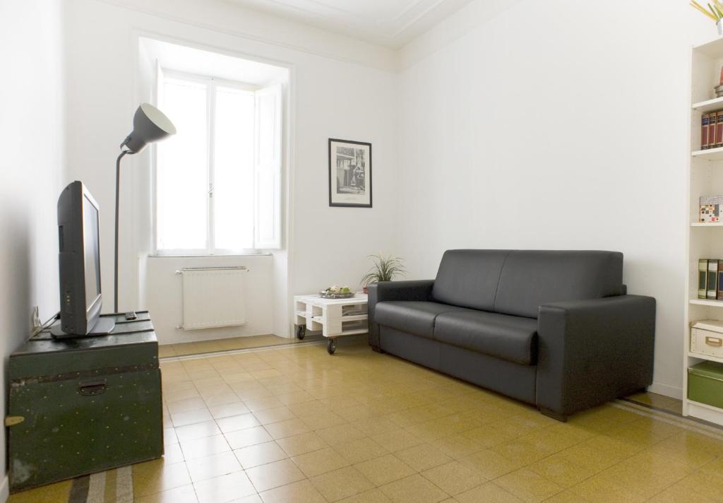 ローマにあるDomus Farneseのリビングルーム(黒いソファ、テレビ付)