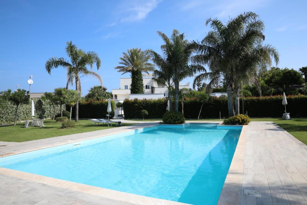 una piscina con palmeras en el fondo en MARGIE'S HOUSE en Procida