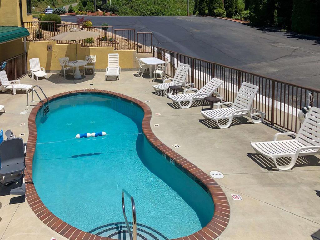 - une piscine avec des chaises longues, une table, une table et des chaises dans l'établissement Quality Inn, à Hillsville