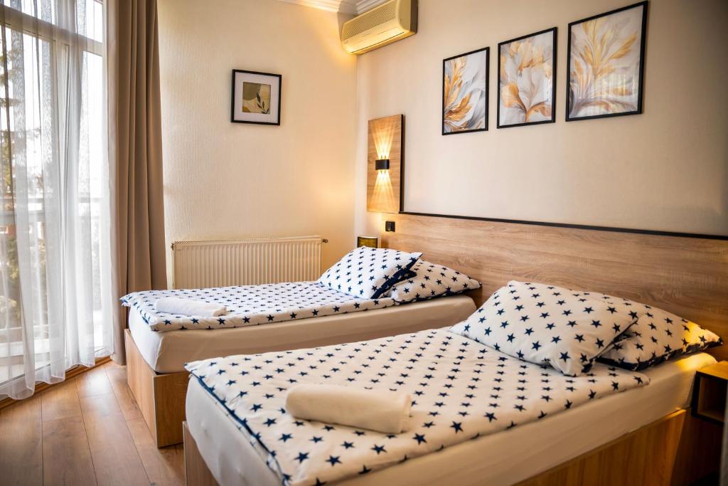 2 Betten in einem Hotelzimmer mit 2 Betten in der Unterkunft Hotel Bolero in Győr