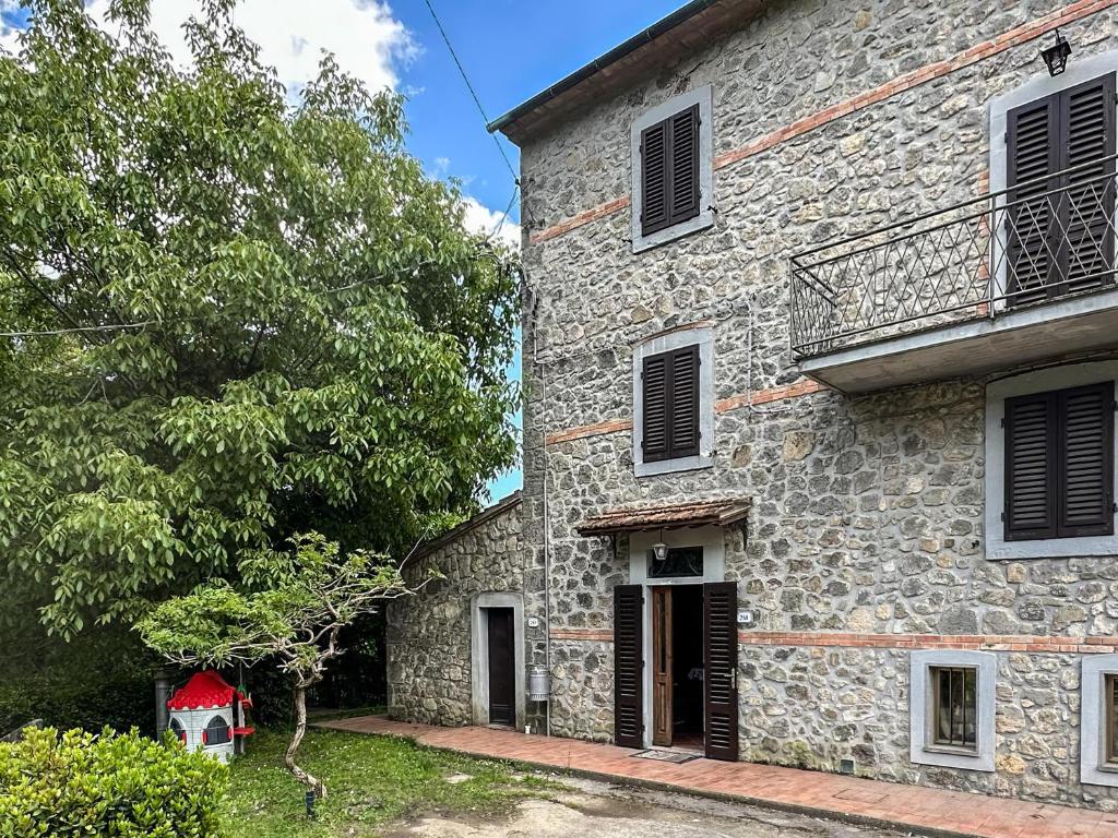 an old stone building with a balcony on it at Renee House in Piancastagnaio