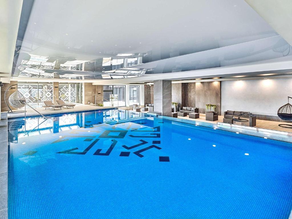 a large blue swimming pool in a building at ibis Styles Nowy Targ in Nowy Targ