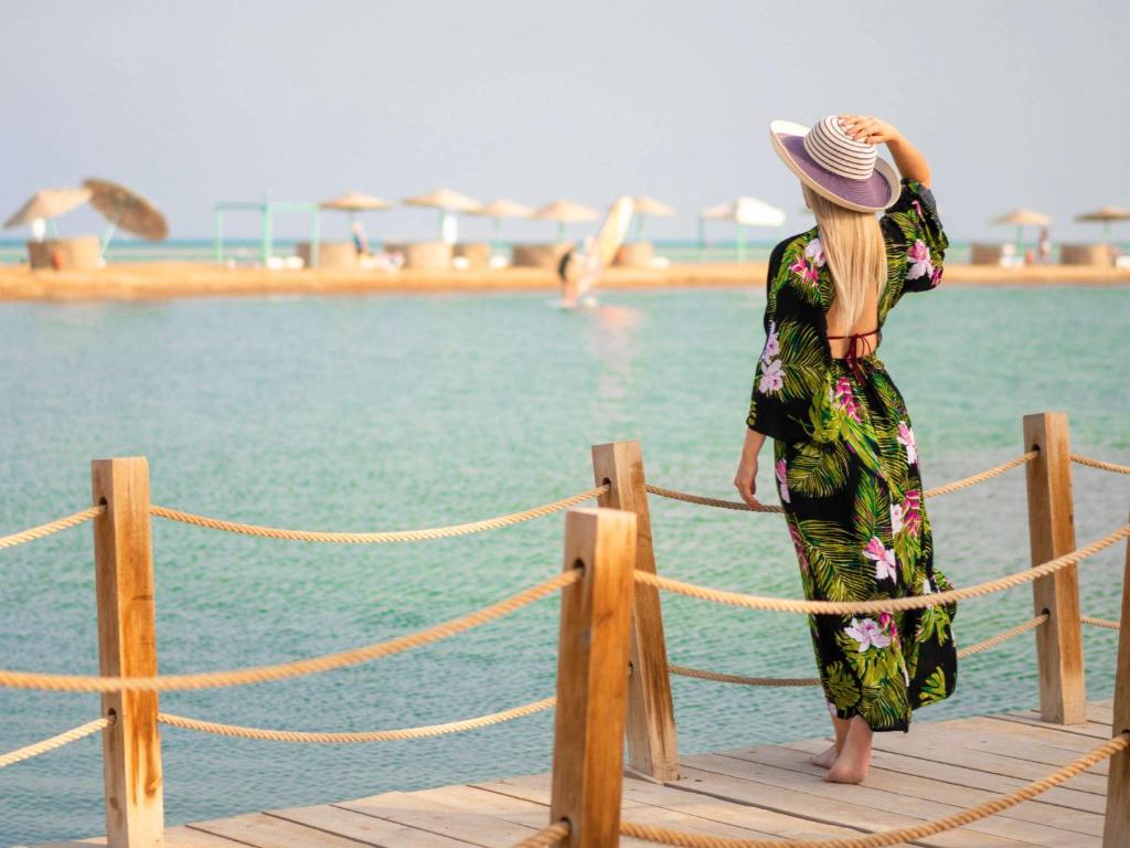 una mujer parada en un muelle cerca del agua en Movenpick Resort & Spa El Gouna, en Hurghada