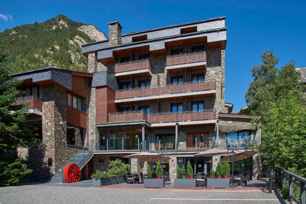 un gran edificio de ladrillo con una rueda roja en el lateral en NH Collection Andorra Palomé, en La Massana